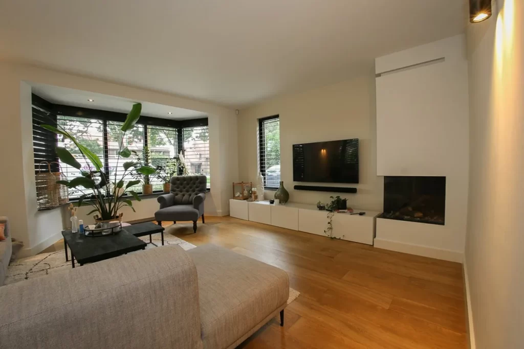 Moderne uitbouw met glazen wanden en houten staanders bij woning aan de Schouw