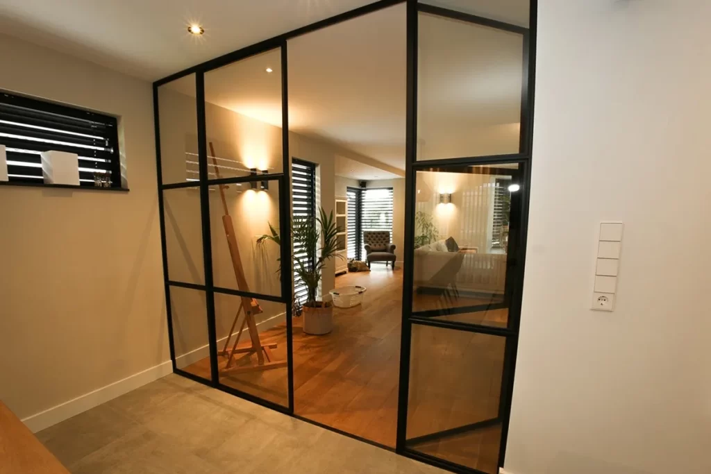 Moderne uitbouw met glazen wanden en houten staanders bij woning aan de Schouw